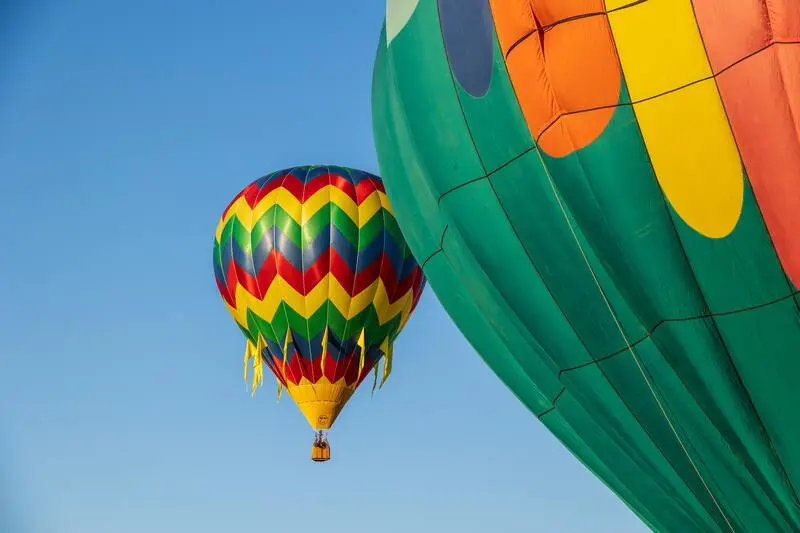 Two colorful hot air balloons flying in the sky.