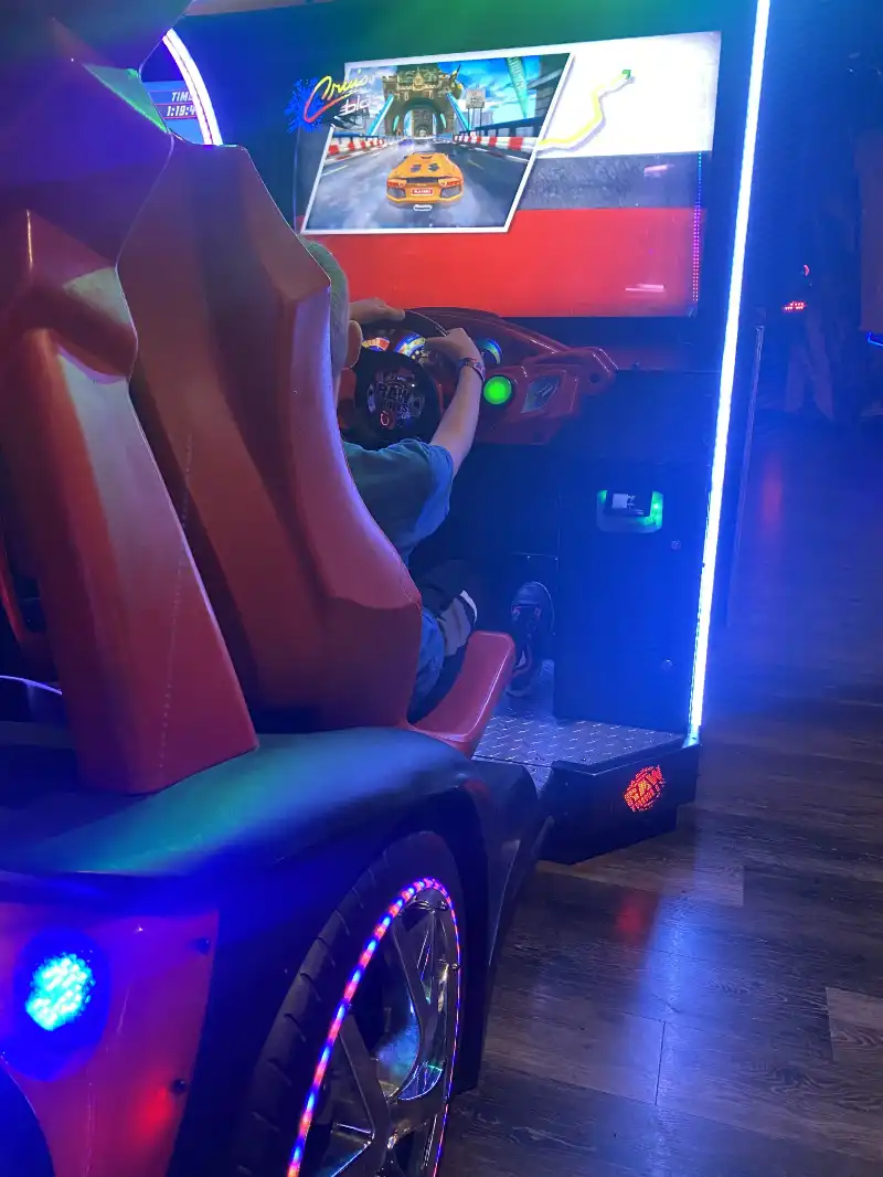 A boy is driving a car at Jake's Unlimited.