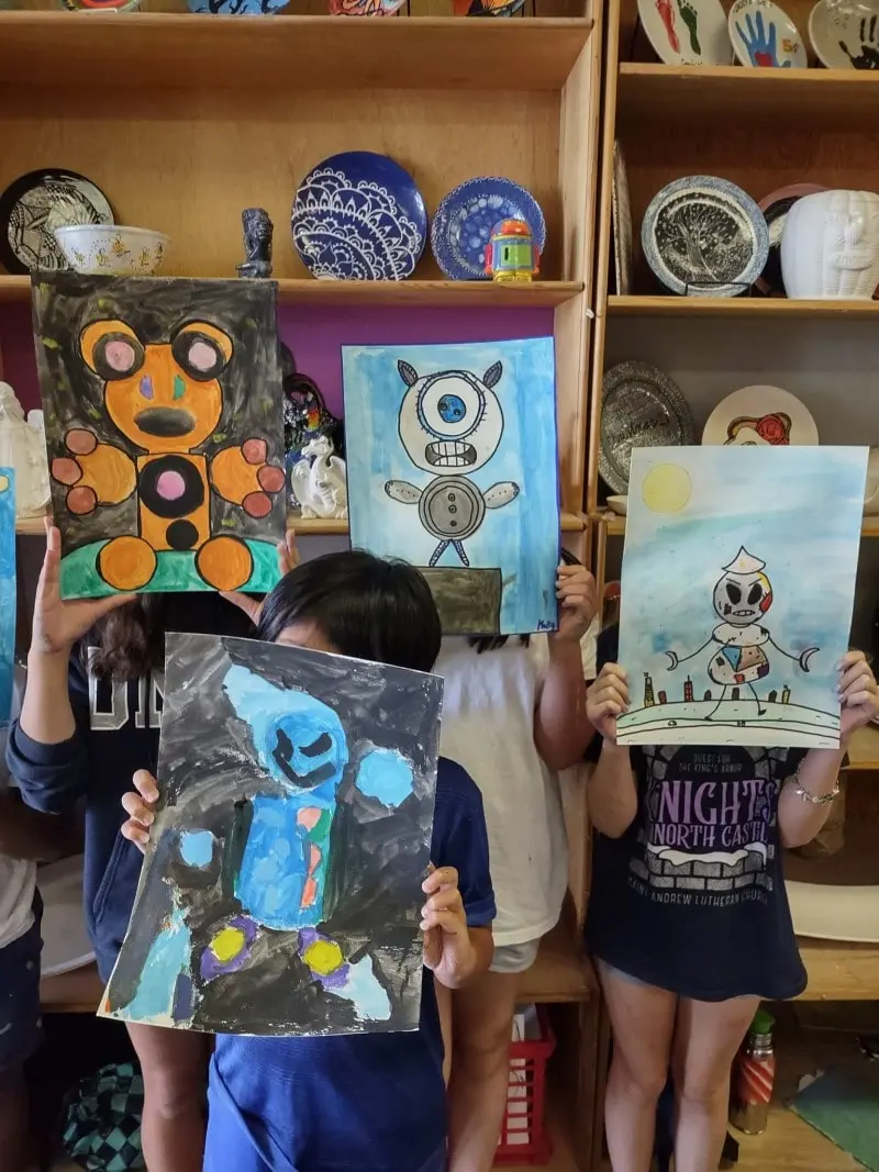 Kids holding up artwork 