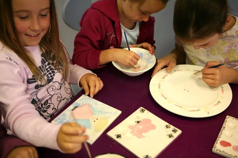 Kids painting pottery