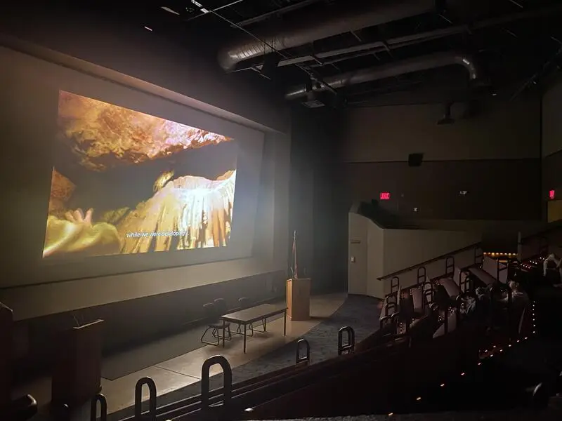 An auditorium displaying a kartchner caverns on-screen.