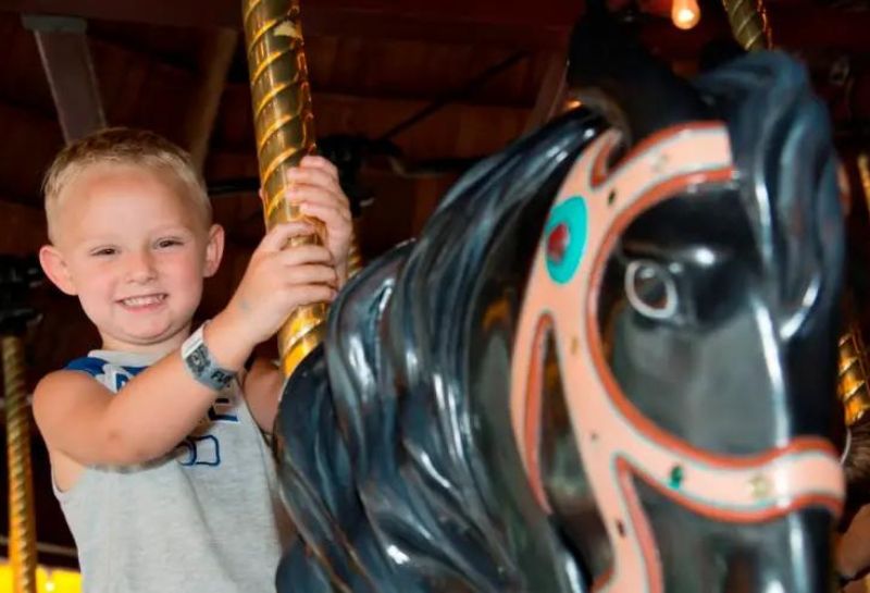 kid riding carousel