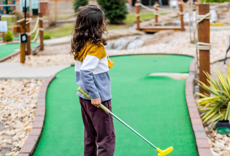 Kid playing mini golf