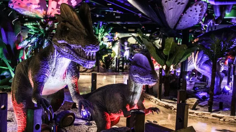 A dinosaur exhibit in a dark room.