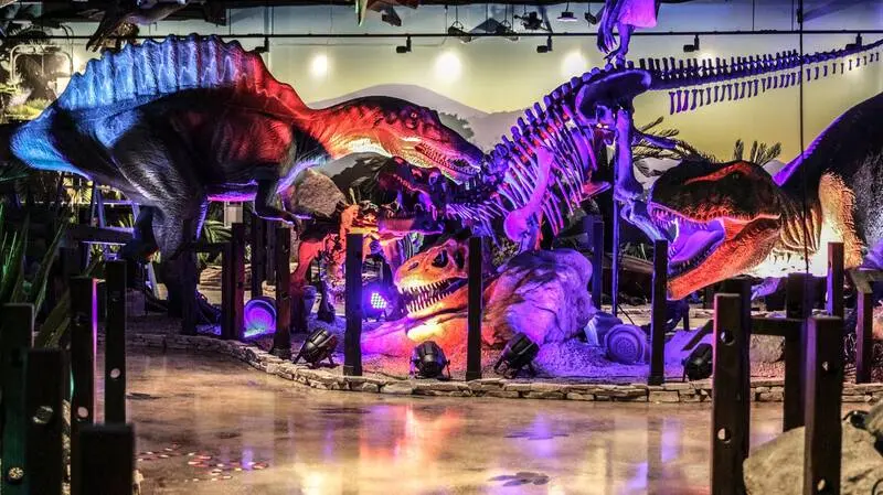 A group of dinosaurs in a museum.