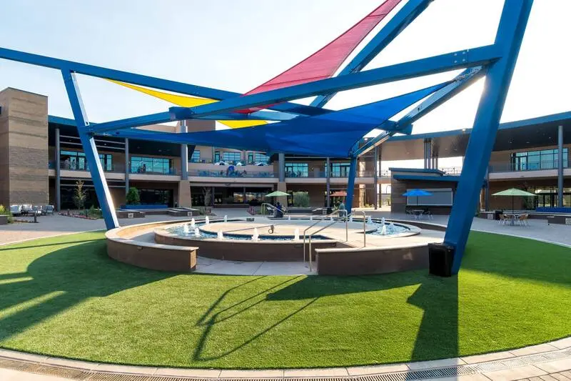 A large outdoor area with a fountain and colorful umbrellas.