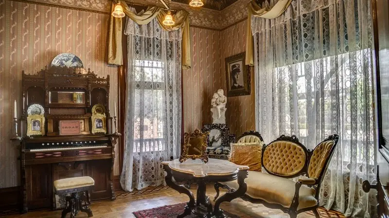 An ornate room with a piano and chairs.