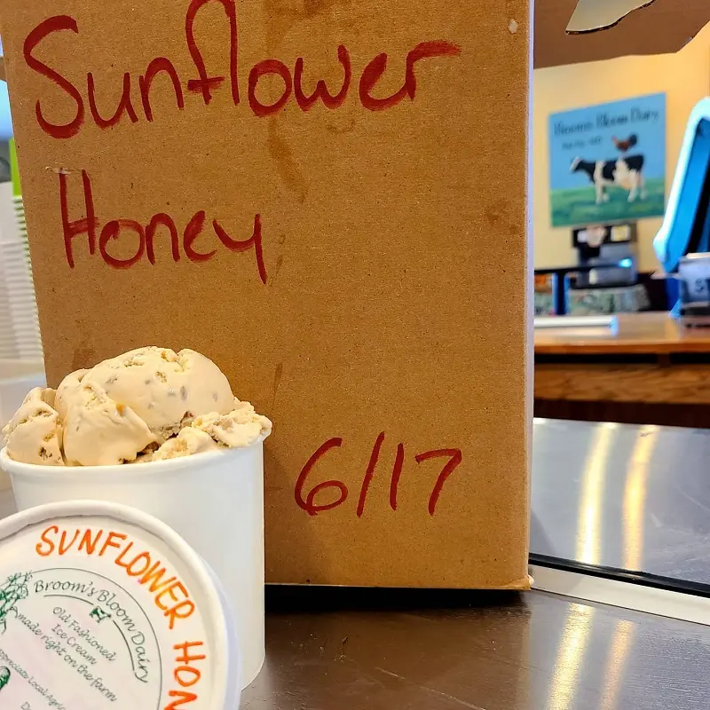 A box of sunflower honey ice cream sits on a counter near sunflower fields in Maryland.