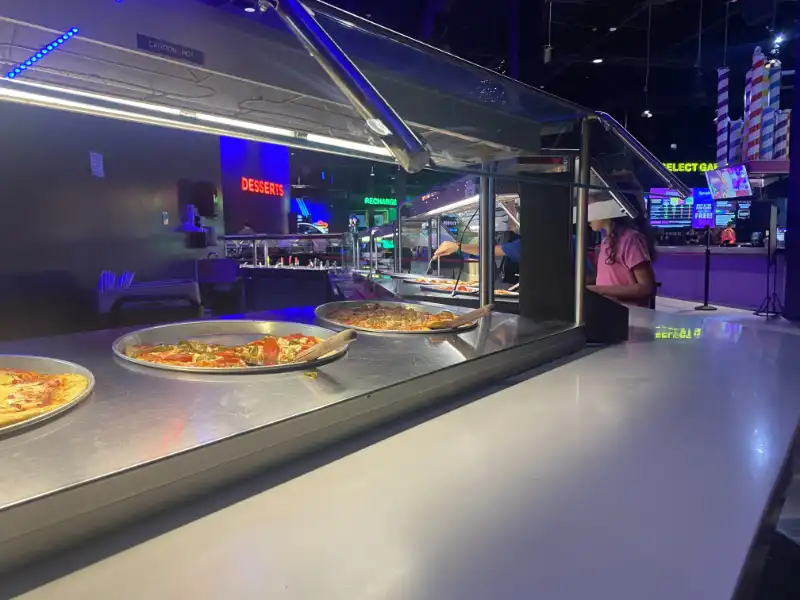 A Jake's Unlimited pizza counter showcasing a variety of pizzas.